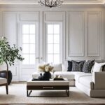 An elegant living room all in white with crown molding on the walls